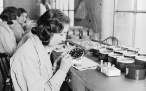 The women working in factory painting clock faces.