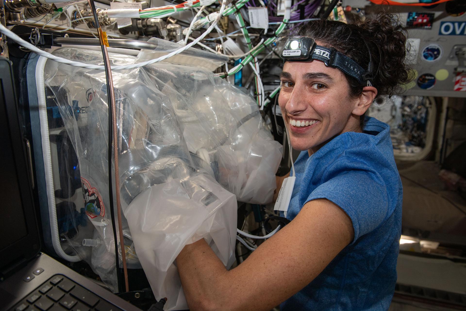 NASA astronaut Jasmin Moghbeli swaps components inside the BioFabrication Facility (BFF)